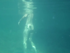 Nudists in the Crimea. Girl underwater in flippers.