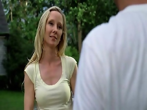 Anne Heche pulling herself up onto a dock beside a lake at