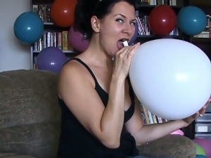 Brunette slut teasing while blowing balloons