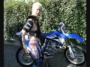 Mature big tit Carina strips out of motorbike gear outdoors